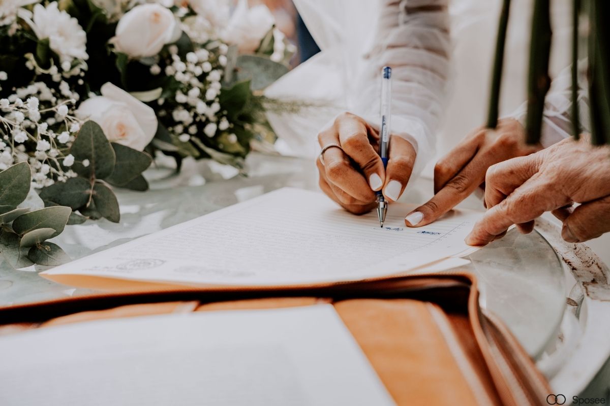 Sposa che legge un preventivo matrimonio al tavolo con contratti e documenti
